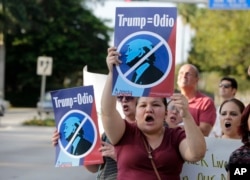 Berta Sandes, 38, of Miami, an undocumented immigrant from Nicaragua, holds a sign that translates to "Trump Equals Hate" during a protest against then-Republican presidential candidate Donald Trump outside the Trump National Doral golf resort, March 14, 2016, in Doral, Fla.