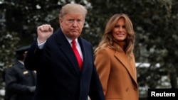 FILE - U.S. President Donald Trump walks with first lady Melania Trump while departing for Palm Beach, Fla., from the White House in Washington, Feb. 1, 2019.