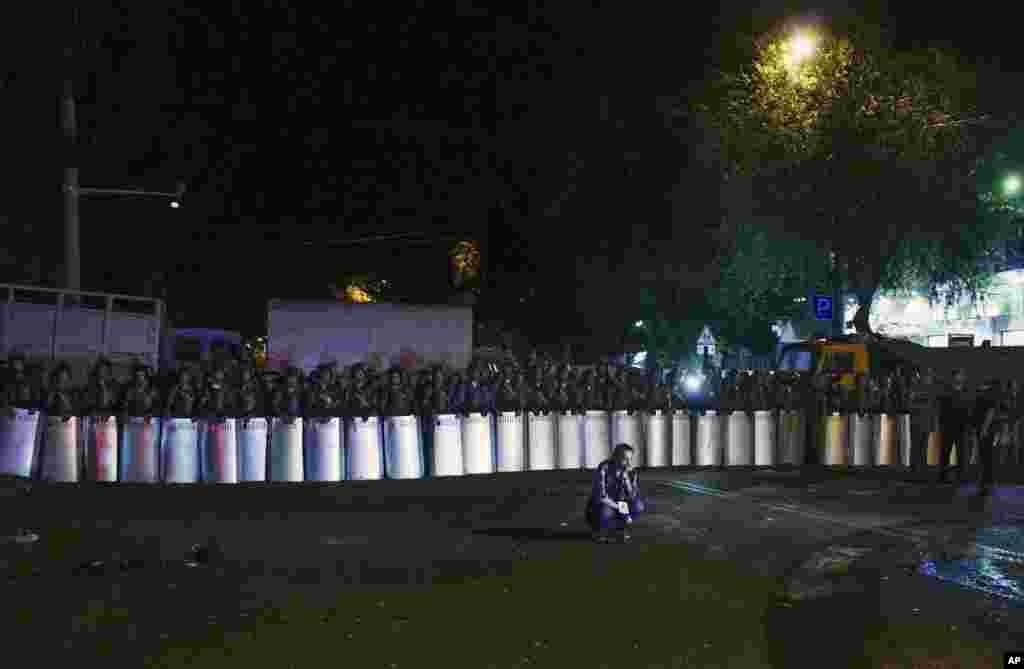 Riot police secure a police station, which is being held by an armed group, in Yerevan, Armenia. A police spokesman says two of the gunmen who have been holding the police station for more than a week have surrendered after an exchange of gunfire.