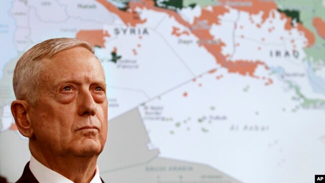 FILE - Secretary of Defense Jim Mattis stands in front of a map of Syria and Iraq, while speaking to the media about the Islamic State group at the Pentagon, May 19, 2017.