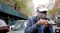 Luis Torres fuma un cigarrillo frente a las casas Chelsea-Elliot de la Autoridad de Vivienda de la Ciudad de Nueva York, donde reside. 12-11-15.
 

