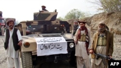 FILE - Members of Tehrik-i-Taliban Pakistan are pictured next to a captured armored vehicle in the Pakistan-Afghanistan border town of Landikotal, Nov. 10, 2008. The Pakistani Taliban have intensified attacks inside Pakistan from bases across the Afghan border in recent months.