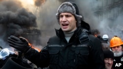 Opposition leader and former WBC heavyweight boxing champion Vitali Klitschko addresses protesters near the burning barricades between police and protesters in central Kyiv, Jan. 23, 2014. 