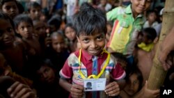 kutupalong ဒုက္ခသည်စခန်းတွင်း တရားဝင် စာရင်းဝင် အသိအမှတ်ပြု ကဒ်ပြားကိုင်ဆောင်ထားတဲ့ ရိုဟင်ဂျာ ကလေးငယ်။