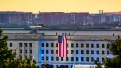 Una bandera estadounidense es desplegada en la sede del Pentágono, en la mañana del 20 aniversario de los ataques terroristas del 11 de septiembre.