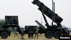 Dutch soldiers are seen standing next to a Patriot missile battery at a military base in Adana, southern Turkey, January 26, 2013.