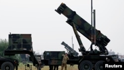 FILE - Dutch soldiers are seen standing next to a Patriot missile battery at a military base in Adana, southern Turkey, January 26, 2013.
