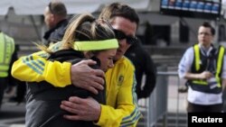 People comfort each other after a bombing at the Boston Marathon, April 16, 2013. 