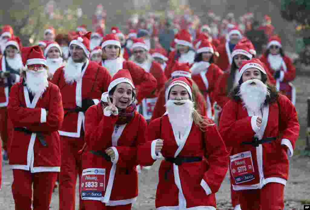 People dressed in Santa Claus costumes take part in a run in Milan, Italy, Dec. 17, 2016.