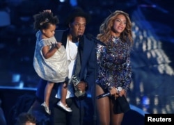 FILE - Jay-Z presents the Video Vanguard Award to his wife, Beyonce, as he holds their daughter, Blue Ivy, during the 2014 MTV Video Music Awards in Inglewood, California, Aug. 24, 2014.