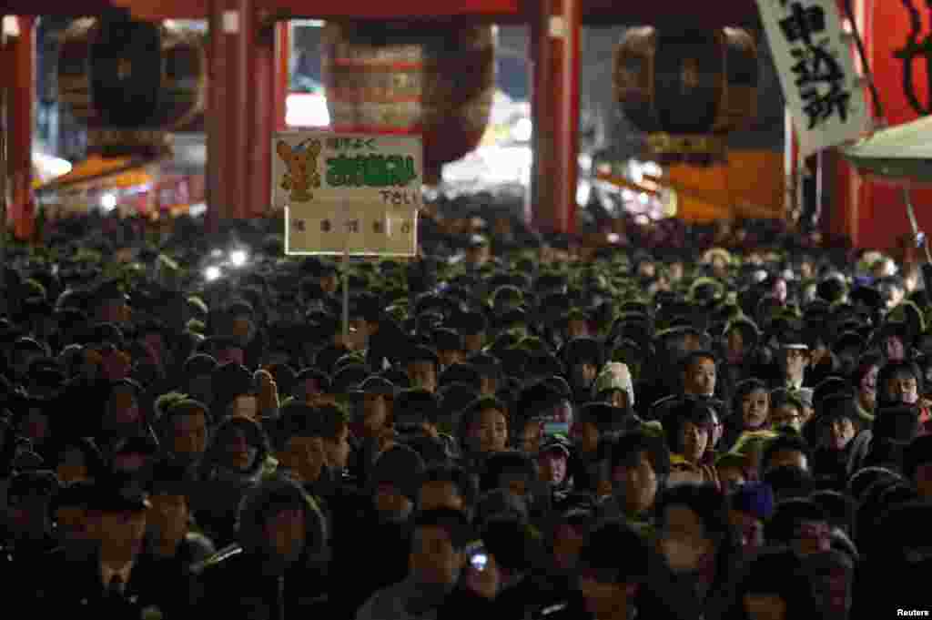 Warga mengantre untuk berdoa di kuil Sensoji, Tokyo, Jepang pada malam pergantian tahun. (Reuters/Yuya Shino)