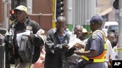Zimbabweans pass a police cordon to submit their application forms outside the Immigration offices in Johannesburg, in a last minute bid to have their status in South Africa legalized (File Photo)