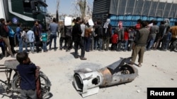 叙利亚首都大马士革附近的杜马镇一个小男孩站在导弹残骸的旁边