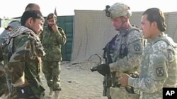 US soldiers (R) talk to Afghan soldiers in training (L)