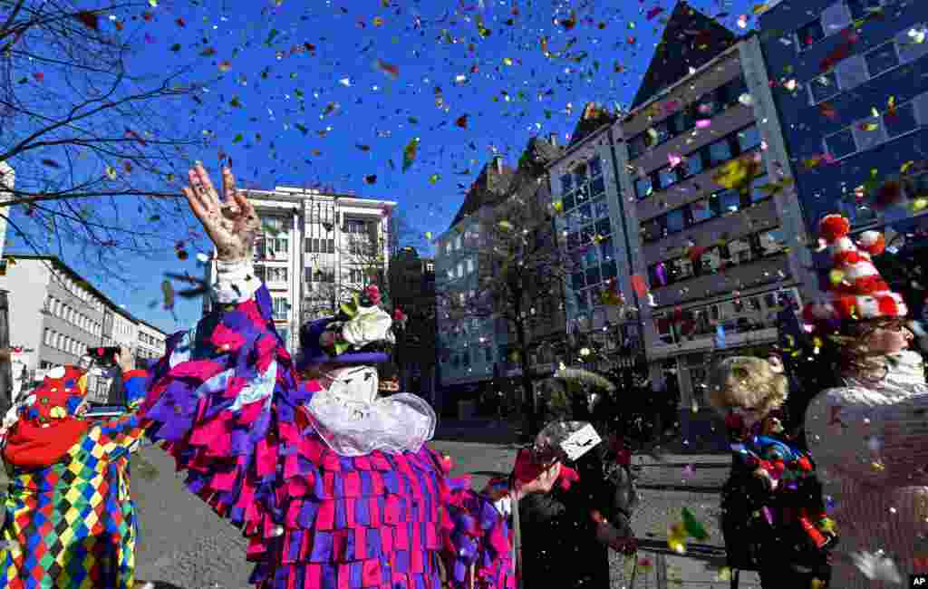 Just a few people in costumes come together at the &quot;Alter Markt&quot; where normally tens of thousands of revelers dressed in carnival costumes would celebrate the start of the street carnival in Cologne, Germany.