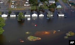 FILE - In this Sept. 17, 2018 file photo, floodwaters from Hurricane Florence surrounds homes in Dillon, South Carolina.