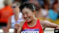 Choeyang Kyi celebrates her third place finish in the women's 20-kilometer race walk at the 2012 Summer Olympics, Saturday, Aug. 11, 2012, in London. (AP Photo/Emilio Morenatti)