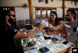 Lebanese raise their glasses of arak in a toast during a festival that celebrates Lebanon's national alcoholic drink, in the town of Taanayel, east Lebanon, Sept. 8, 2018.