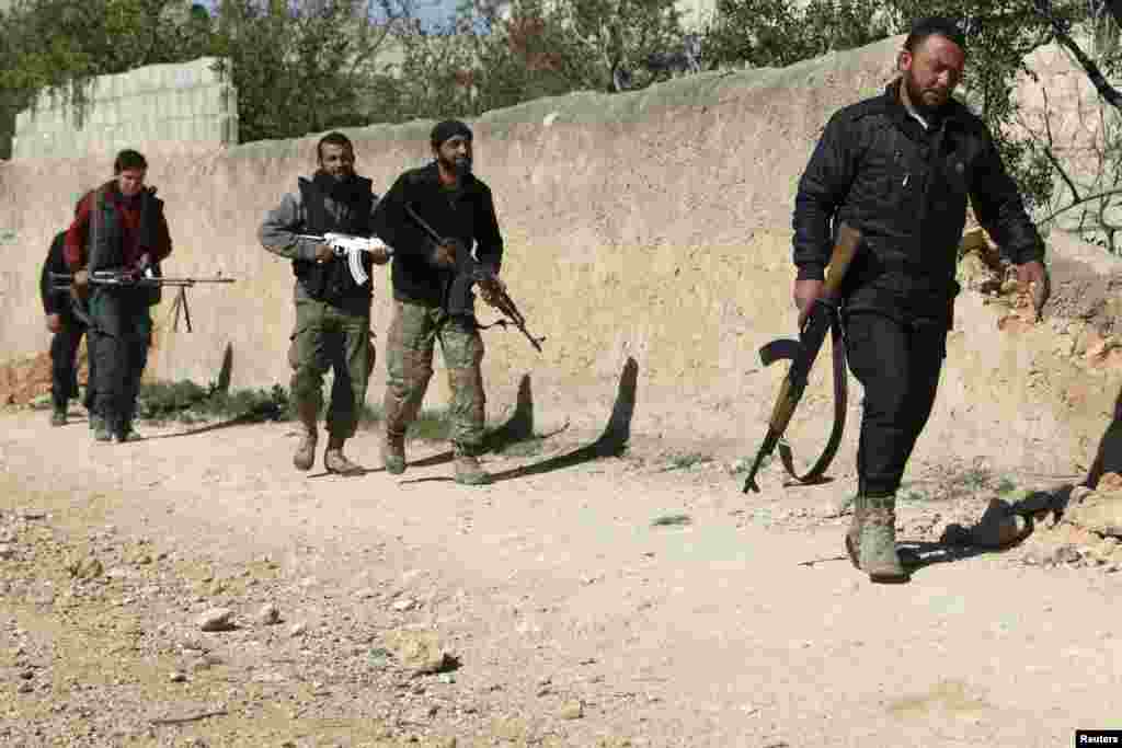 Free Syrian Army fighters walk with their weapons in Azaz village, north of Aleppo, March 30, 2014.