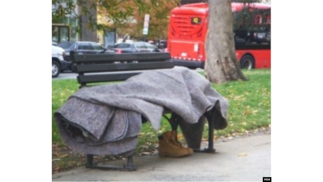 Seorang tunawisma tidur berbalut selimut di bangku taman di pusat kota Washington DC. Setiap tahun sekitar 700 tunawisma di AS tewas akibat hipotermia.