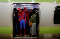 Peserta Halloween, mengenakan kostum Spiderman, naik kereta setelah malam Halloween di distrik Shibuya Tokyo, 1 November 2014. (Foto: REUTERS/Yuya Shino)