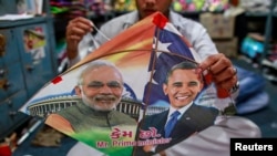 Seorang pekerja di Mumbai, tengah menjahit layang-layang bergambar PM India Narendra Modi (kiri) dan Presiden AS Barack Obama, menyambut kedatangan Presiden Obama ke negara tersebut (23/1).