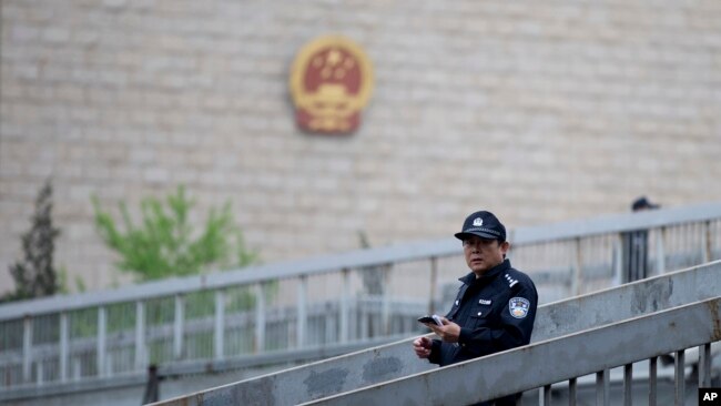 资料照：一名警察在北京审理维权律师许志永案的中国最高人民法院外巡逻。（2014年4月11日）