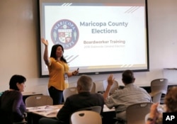 FILE - Maricopa County Elections official Brittney Johnson instructs election volunteers during a training session in Phoenix, Oct. 31, 2018.