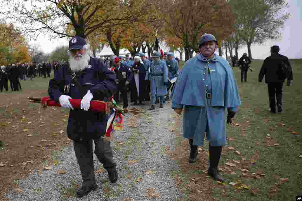 Actores vestidos de soldados marchan al culminar la ceremonia de conmemoración por el centenario del fin de la I Guerra Mundial.