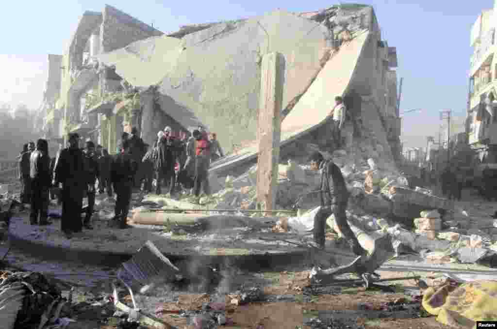 People inspect a site damaged by what activists said was an air raid by forces loyal to Syrian President Bashar Al-Assad in the al-Marja district of Aleppo, Dec. 23, 2013.&nbsp;
