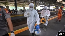 Para petugas menyemprotkan disinfektan di stasiun Gambir, untum mencegah perebakan virus corona di Jakarta (foto: dok). 
