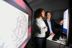 In this Friday, June 7, 2019 photo provided by the University of California, San Francisco, Dr. Edward Chang, right, and postdoctoral scholar David Moses work at UCSF's Mission Bay campus.