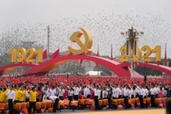Para hadirin mengibarkan bendera China dalam upacara di Lapangan Tiananmen untuk menandai peringatan 100 tahun berdirinya Partai Komunis China yang berkuasa di Beijing, Kamis, 1 Juli 2021. (AP Photo/Ng Han Guan)