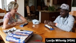 Fabrice Hampoh plays a game with his host mother in her home in Mesa, Arizona.