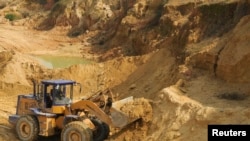 资料照片：江西省南城县一个稀土矿的铲车工人在工作。（2010年10月31日）