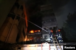 Firefighters work at the scene of a fire that broke out at a chemical warehouse in Dhaka, Bangladesh, Feb. 20, 2019.