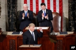 President Donald Trump, flanked by Vice President Mike Pence and House Speaker Paul Ryan, gestures on Capitol Hill in Washington, Feb. 28, 2017, before his address to a joint session of Congress.