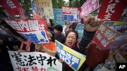 Protesters gather in front of the Diet building in Tokyo, Sept. 28,2017, after Japanese Prime Minister Shinzo Abe dissolved the lower house of parliament, paving the way for a snap election. The banner at top in the center reads: "Abe cabinet, go out of office."