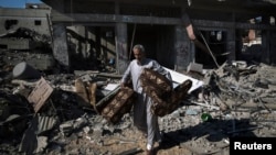 A Palestinian man salvages belongings from damaged buildings in the Shejaia neighborhood, which witnesses said was heavily hit by Israeli shelling and air strikes, in Gaza City July 27, 2014. 
