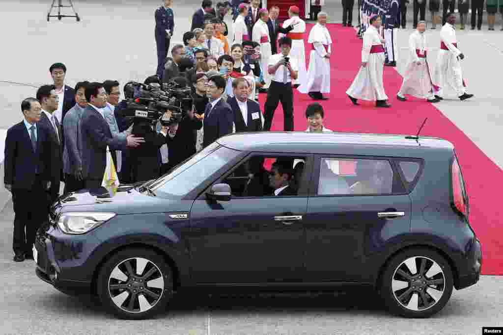 Pope Francis in his popemobile car as South Korean President Park Geun-hye watches upon his arrival at Seoul Air Base in Seongnam, August 14, 2014.