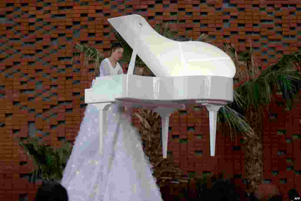 Eleanora Costantini, a 25-year-old pianist from Italy, plays a song on the Flying Piano at the Opportunity Pavilion Plaza of the Dubai Expo.