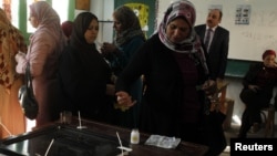 A woman dips her finger in ink after casting her vote in a referendum on Egypt's new constitution, at a school used as a polling station in Alexandria, Egypt, December 15, 2012.
