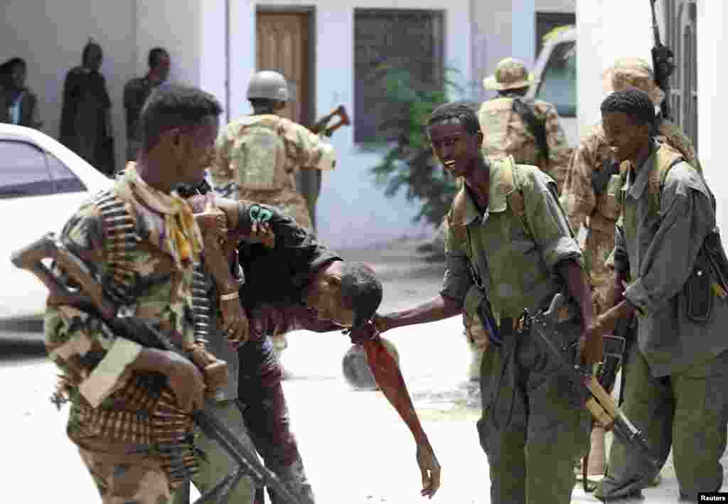 Somali soldiers help a wounded civilian, Mogadishu, April 14, 2013. 