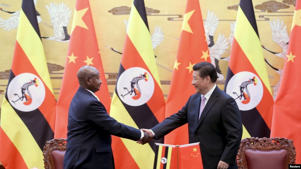 FILE - Ugandan President Yoweri Kaguta Museveni, left, shakes hands with Chinese President Xi Jinping during a signing ceremony in the Great Hall of the People in Beijing, March 31, 2015.