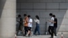 北京一群青年边走路边看手机。（2020年7月6日）