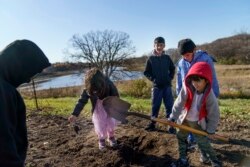 Ali Patan, 7, right, shovels dirt while looking for worms with his brothers, Sala and Maiwan, and cousins Laiba and her brother, Haiwad, while visiting the farm of Caroline Clarin in Dalton, Minn., Oct. 30, 2021.