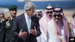 FILE - U.S. Secretary of State John Kerry, left, and Saudi Foreign Minister Saud al-Faisal walk together upon Kerry's arrival at King Abdulaziz International Airport in Jeddah, Saudi Arabia.