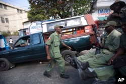 Armed, former members of Haiti's disbanded army patrol the streets while simultaneous pro- and anti-government protests take place in Port-au-Prince, Haiti, Feb. 5, 2016.