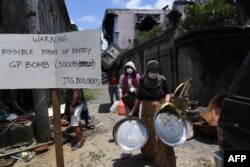 Residents carry belongings collected from their destroyed house during a visit to the main battle area in Marawi City, in southern island of Mindanao on April 1, 2018.