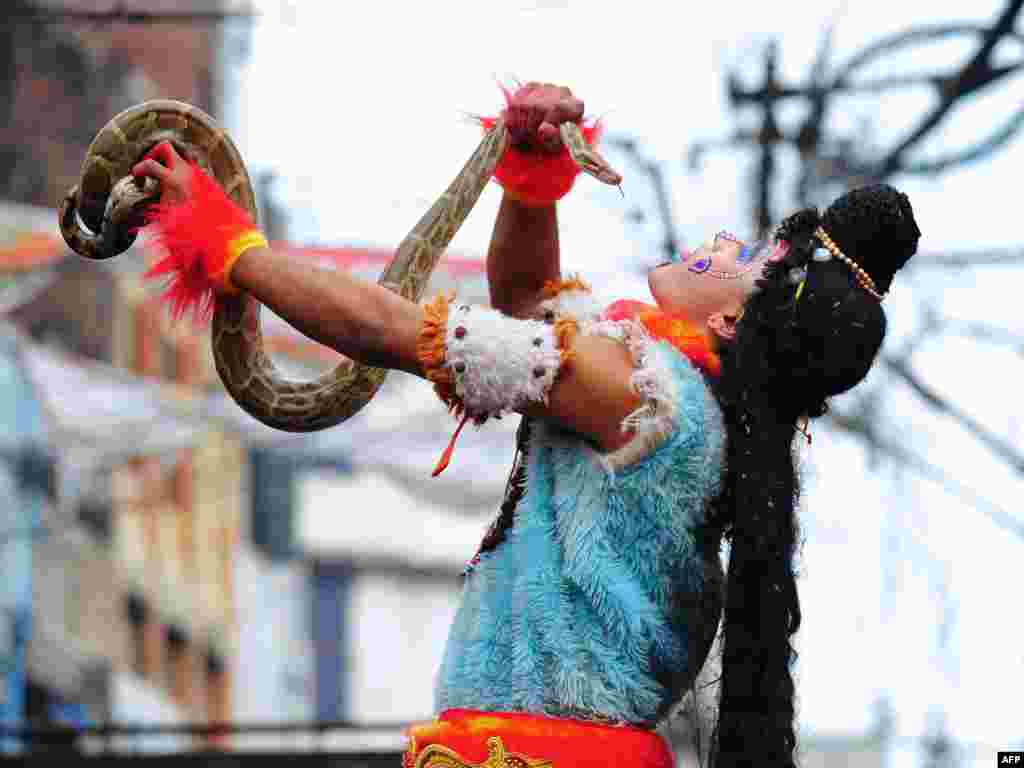 Seorang penganut Hindu India memegang ular python dalam prosesi untuk Maha Shivaratri, yang didedikasikan untuk dewa Hindu Siwa, di Allahabad, India. Penganut Hindu menandai festival Maha Shivratri dengan memanjatkan doa-doa khusus dan berpuasa bagi Siwa, dewa pelebur.